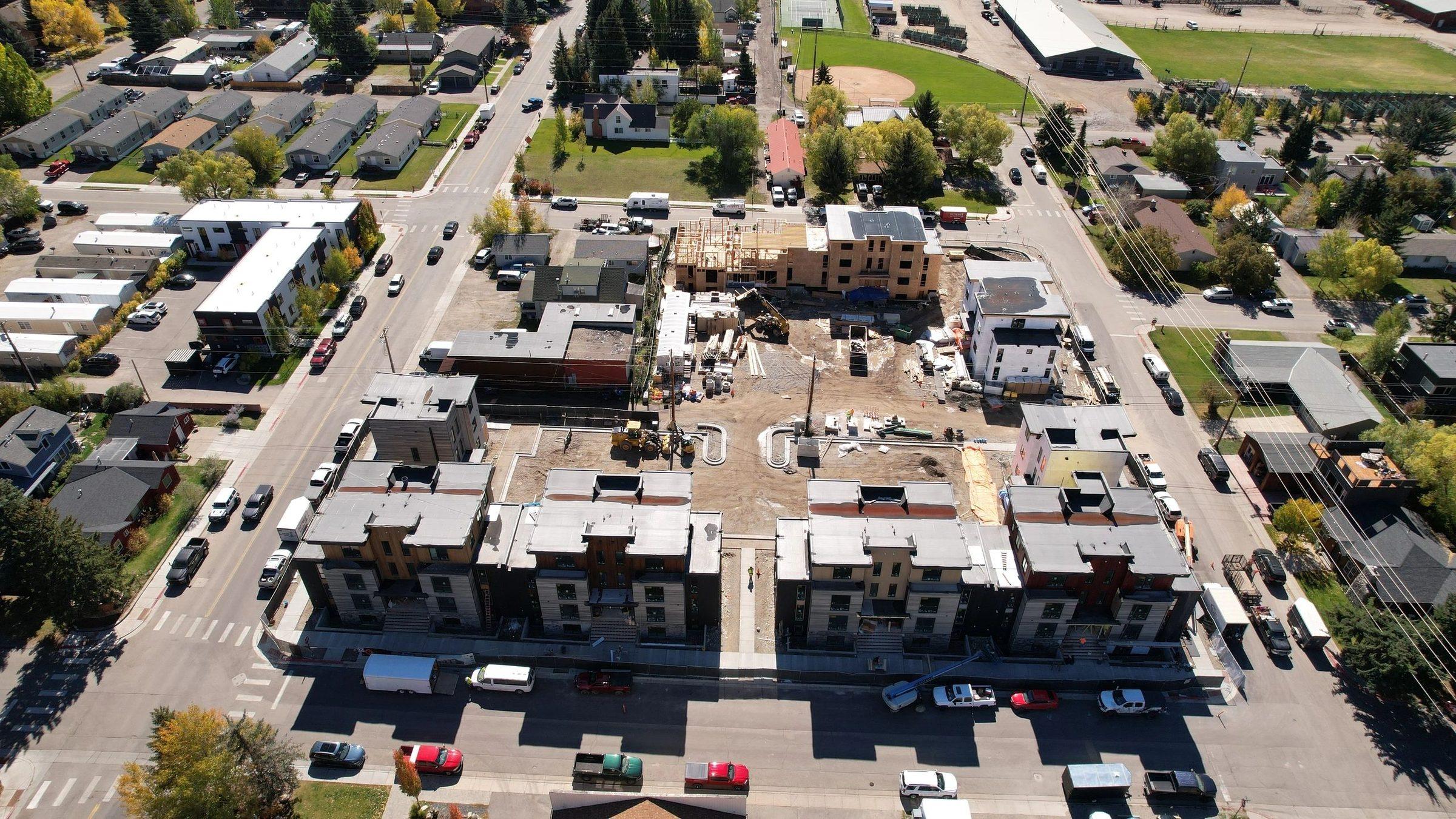 Aerial view of new apartment buildings in a mountain town, with the street grid around them